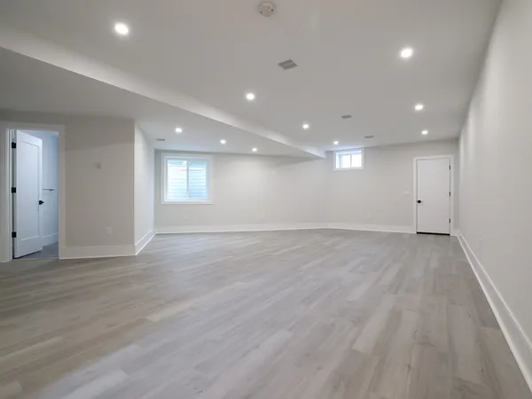 a view of an empty room with wooden floor and entryway