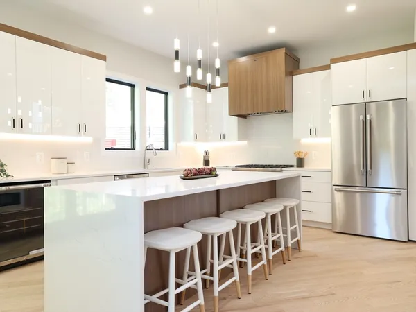 a kitchen with stainless steel appliances granite countertop a table chairs sink refrigerator and microwave