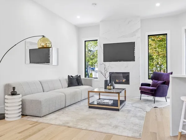 a living room with furniture a flat screen tv and a fireplace