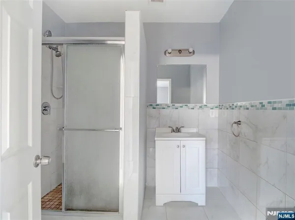 a bathroom with a shower a mirror and a sink