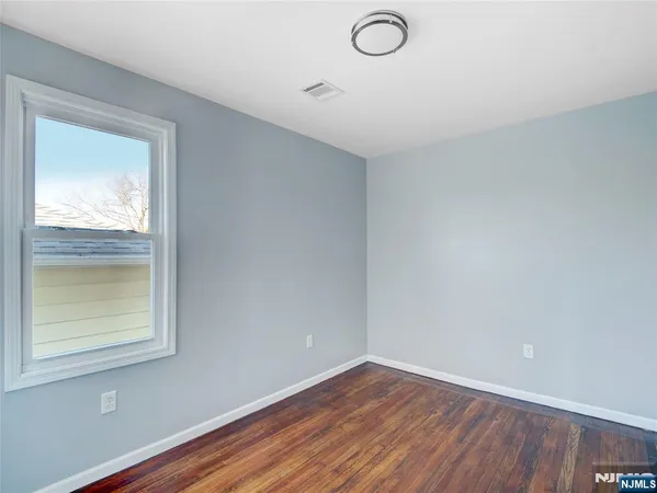 a view of a small space with wooden floor and a window