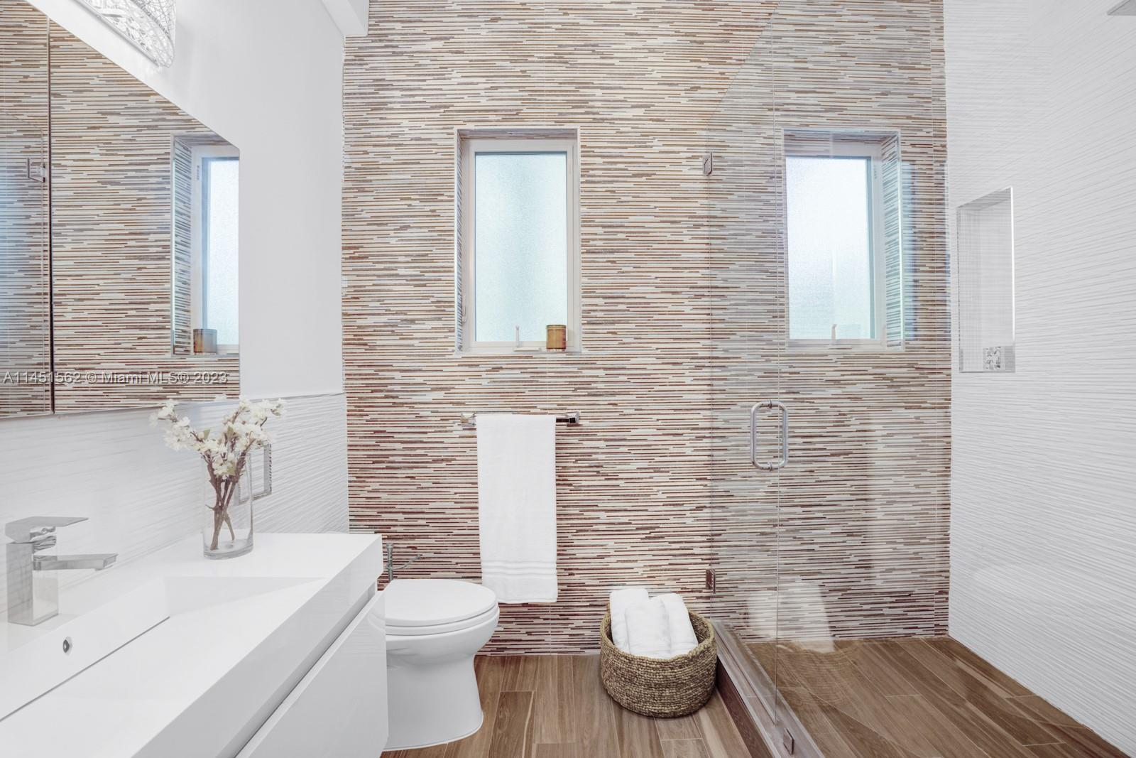 761 Buttonwood Lane Miami, FL 33137 - Photo 30 of 64 a bathroom with a toilet a sink and mirror