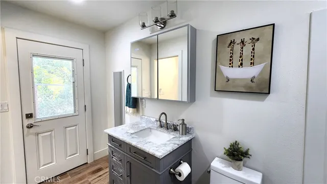 a living room with stainless steel appliances furniture a rug and a view of kitchen