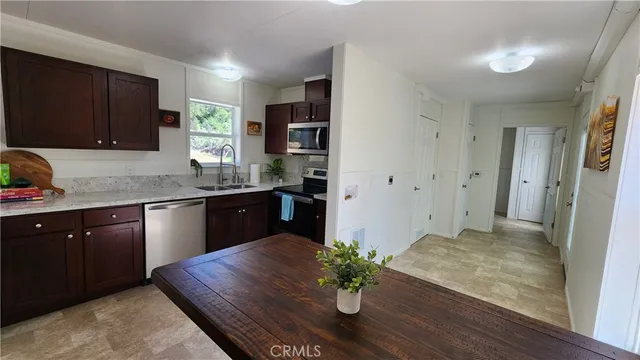 a kitchen with stainless steel appliances granite countertop a sink dishwasher stove and refrigerator