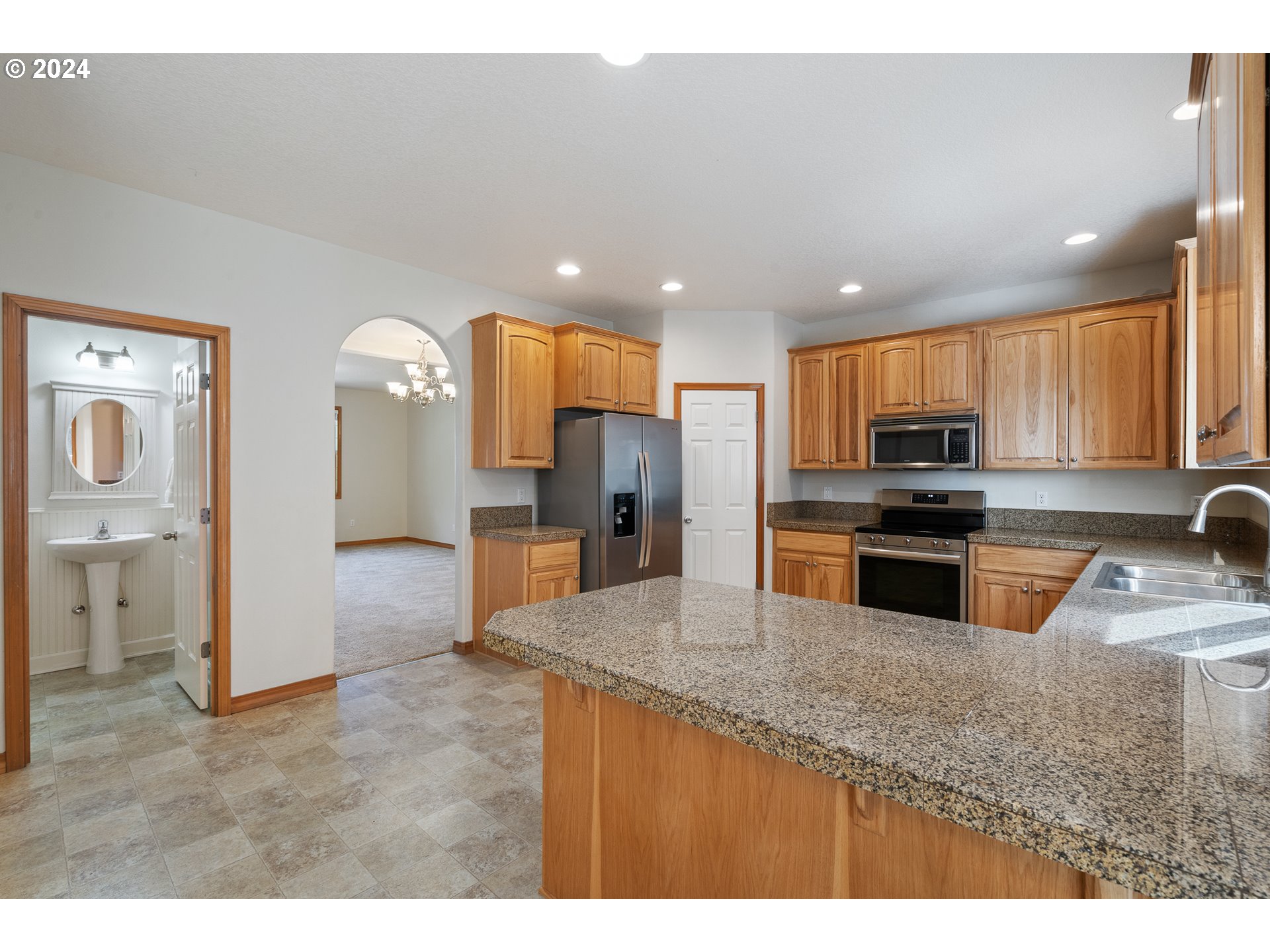 8009 Northeast 16th Street Vancouver, WA 98664 - Photo 13 of 46 a kitchen with granite countertop a refrigerator oven a sink a dining table and chairs