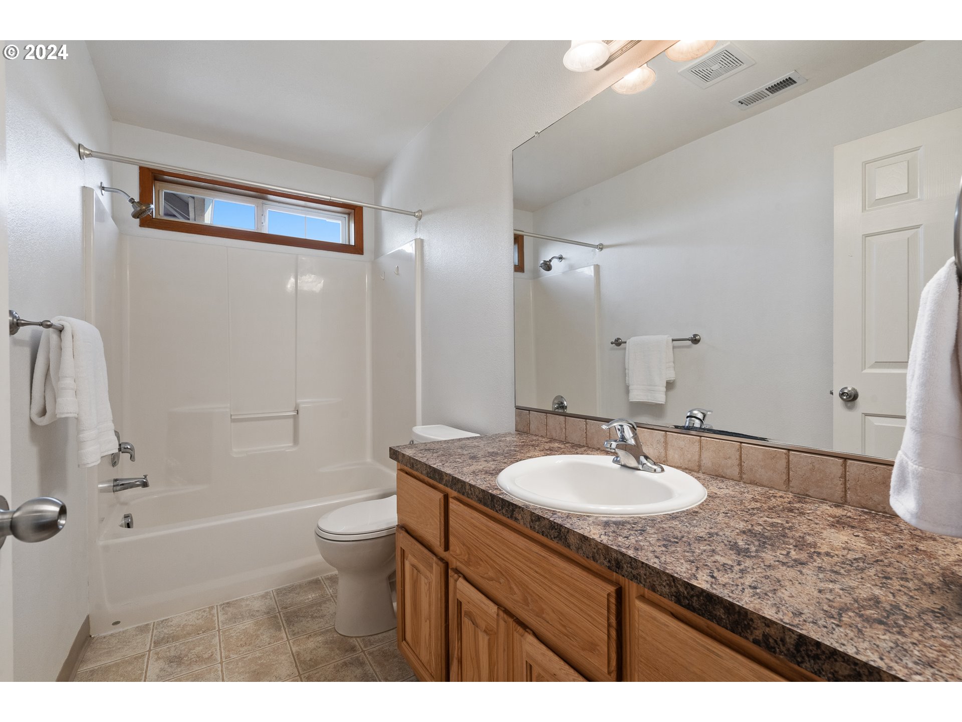 8009 Northeast 16th Street Vancouver, WA 98664 - Photo 26 of 46 a bathroom with a granite countertop sink a toilet a mirror and shower