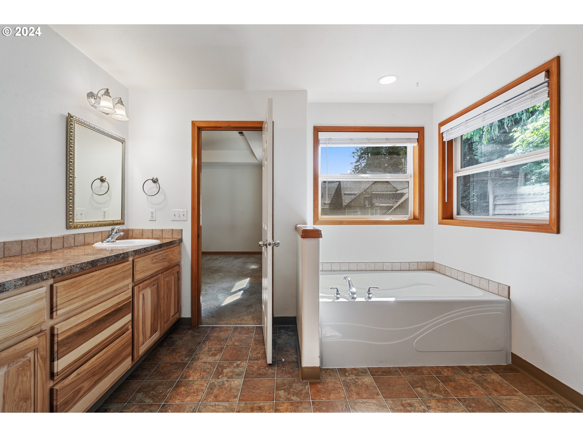 8009 Northeast 16th Street Vancouver, WA 98664 - Photo 33 of 46 a spacious bathroom with a granite countertop sink a mirror and a bathtub