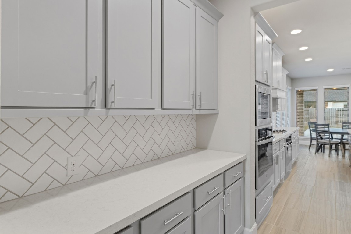 17467 Bayflower Conroe, TX 77385 - Photo 11 of 44 a kitchen with a white cabinets and wooden floor