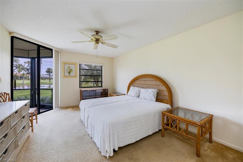 415 Augusta Boulevard, Unit 110 Naples, FL 34113 - Photo 19 of 31 a bedroom with a bed and a table in it