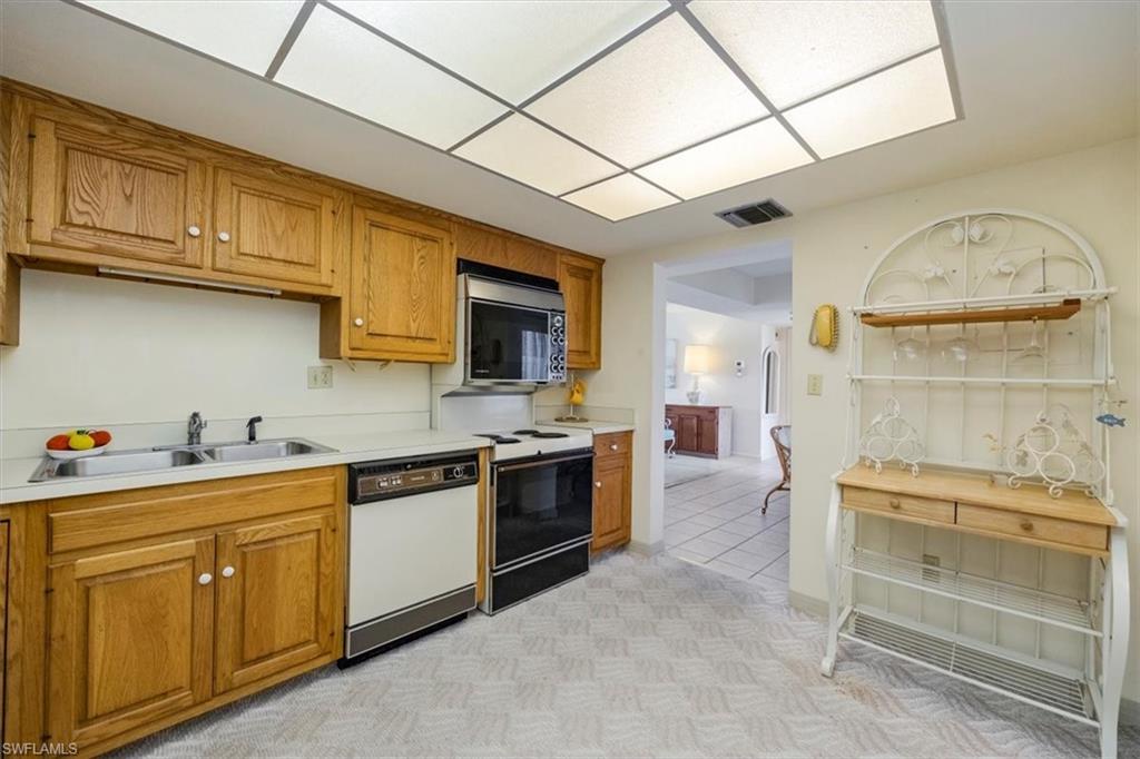 415 Augusta Boulevard, Unit 110 Naples, FL 34113 - Photo 22 of 31 a kitchen with a stove a sink and cabinets