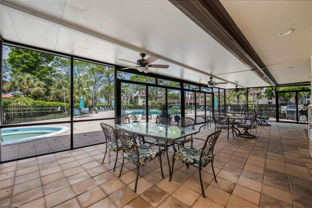 415 Augusta Boulevard, Unit 110 Naples, FL 34113 - Photo 29 of 31 a view of a swimming pool with a table and chairs