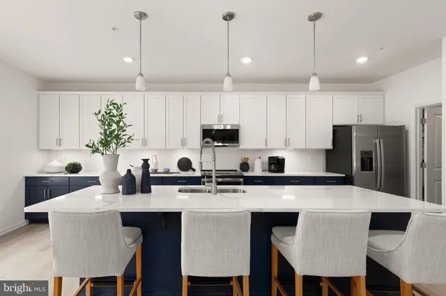 a kitchen with stainless steel appliances kitchen island granite countertop a sink a stove and a wooden cabinets