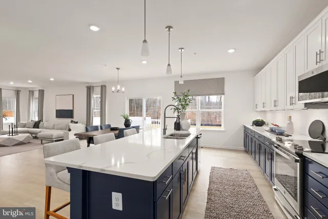 a kitchen with appliances a sink a counter top space and living room view