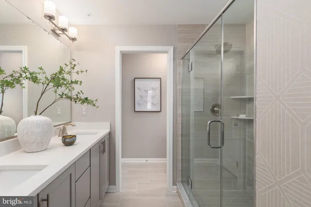 a bathroom with a glass shower door and a sink