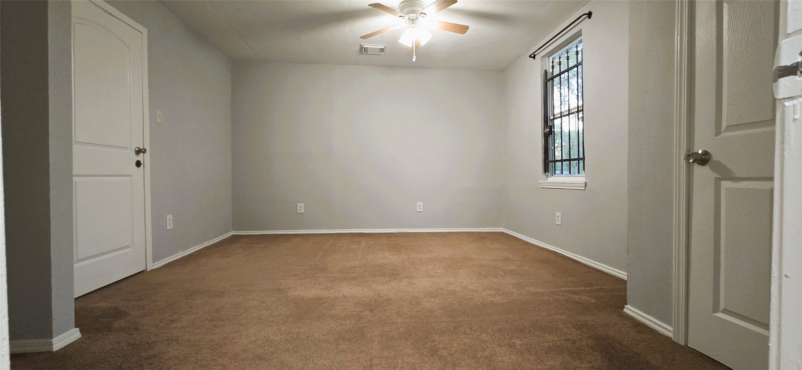 9410 Rosehaven Drive Houston, TX 77051 - Photo 4 of 8 an empty room with windows and chandelier fan