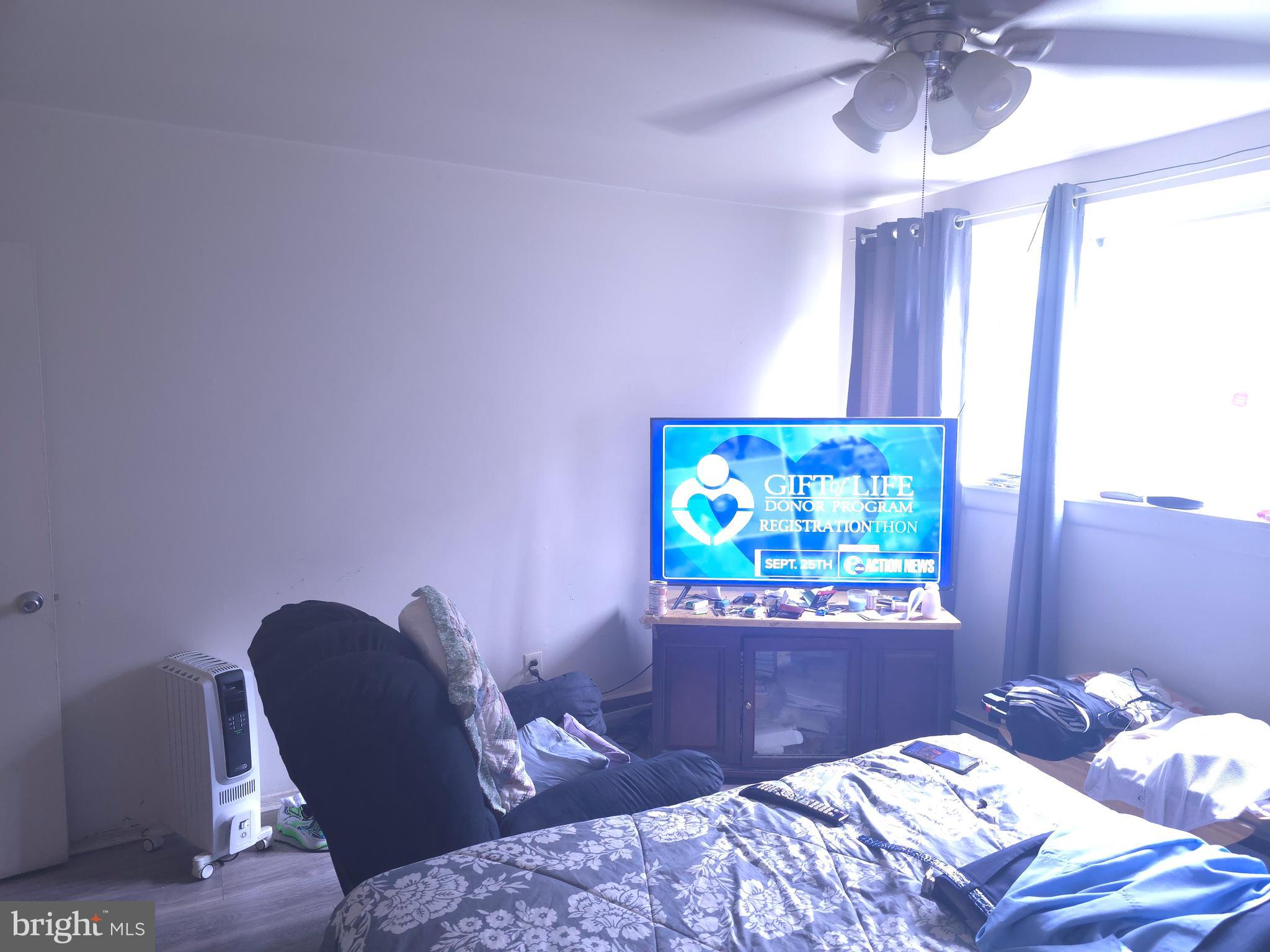 8125 West Chester Pike, Unit A4 Upper Darby, PA 19082 - Photo 12 of 14 a bedroom with a bed and a chandelier