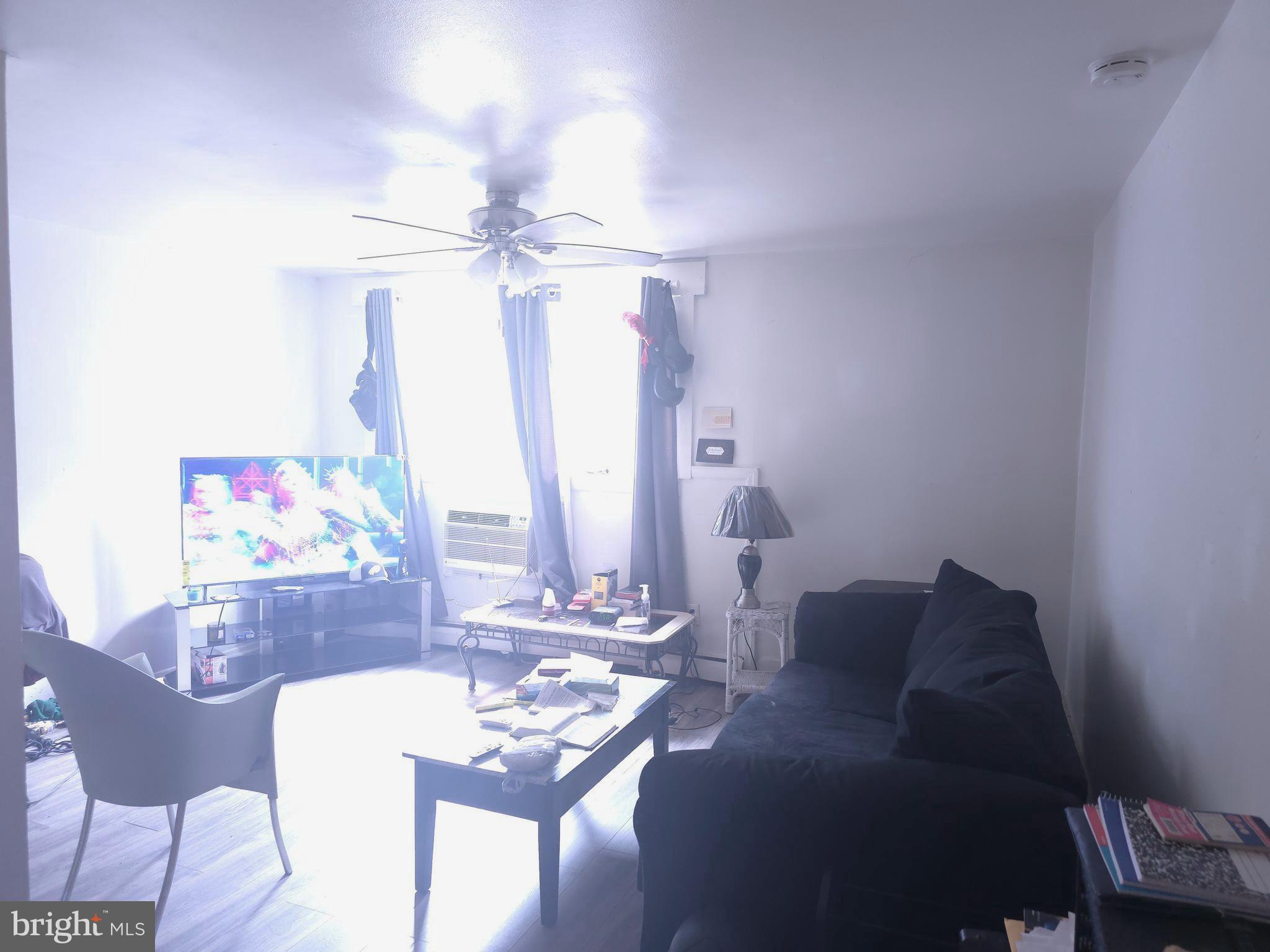 8125 West Chester Pike, Unit A4 Upper Darby, PA 19082 - Photo 9 of 14 a living room with furniture and a chandelier