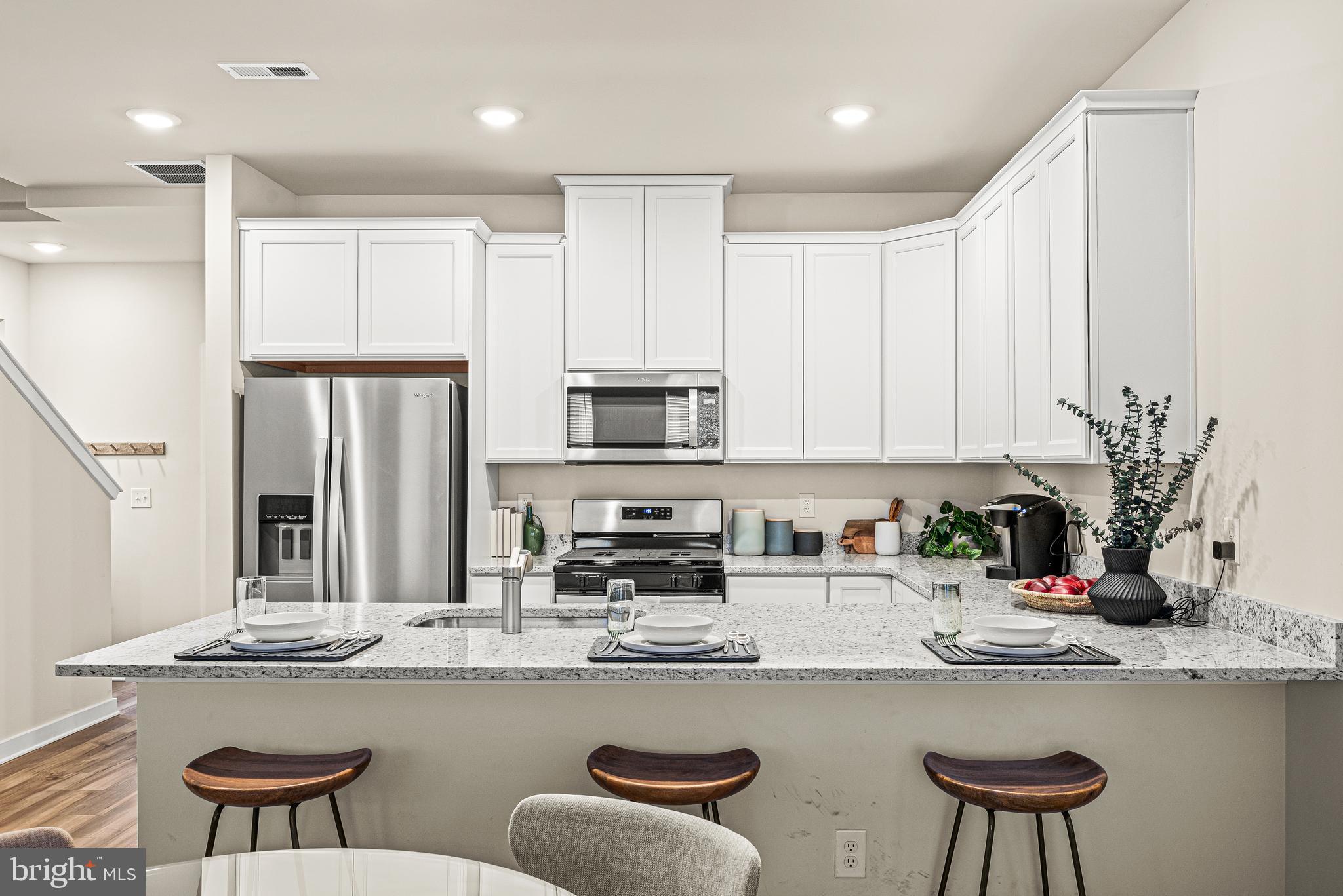 13B Ford Street, Unit A Bridgeport, PA 19405 - Photo 11 of 26 a kitchen with stainless steel appliances granite countertop a kitchen island a stove a table and chairs in it