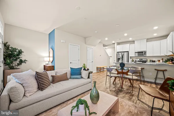 a living room with furniture kitchen view and a potted plant