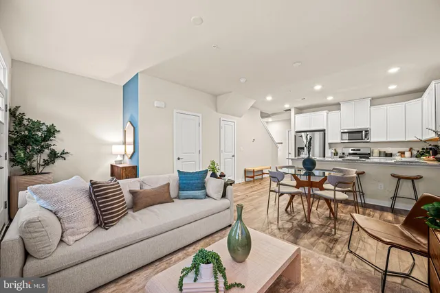 a living room with furniture kitchen view and a potted plant
