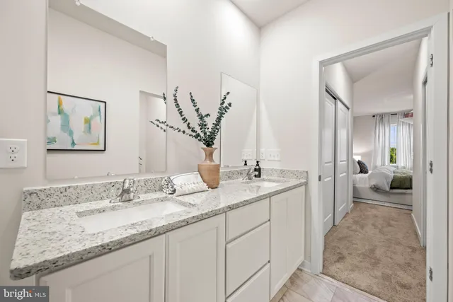 a en suite bathroom with a granite countertop sink and a mirror