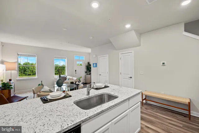 a kitchen with sink and view of living room
