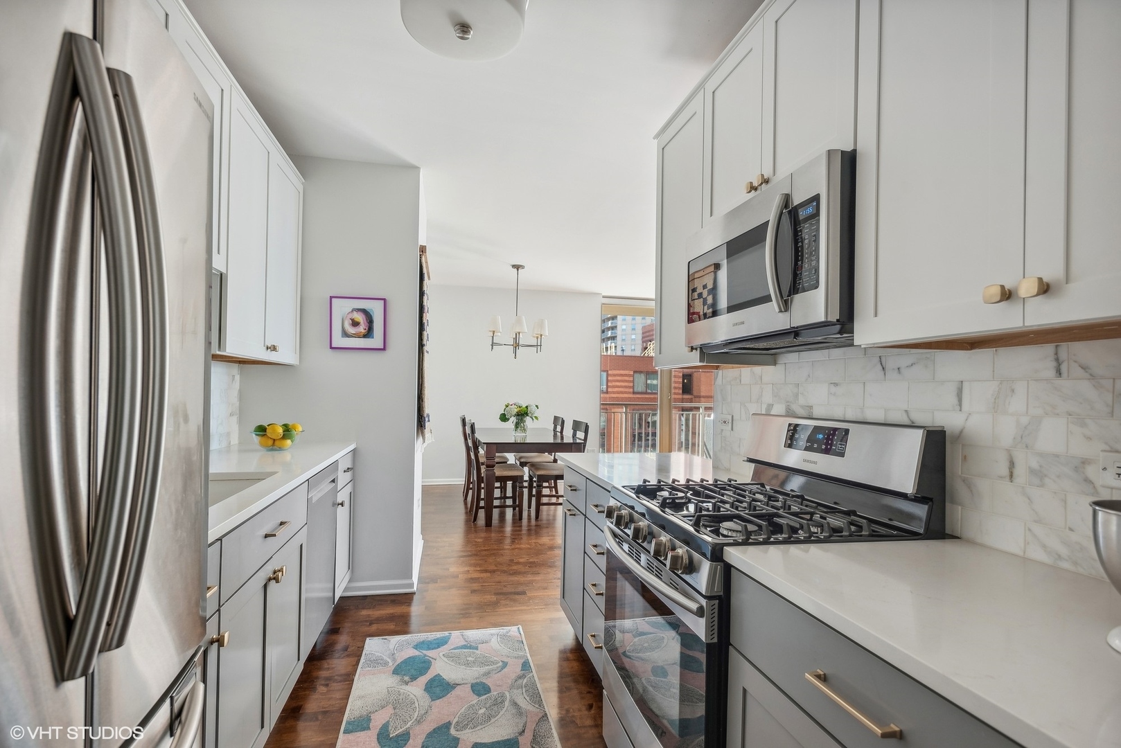 630 North State Street, Unit 1108 Chicago, IL 60654 - Photo 11 of 22 a kitchen with stainless steel appliances granite countertop a stove top oven a sink a dining table and chairs