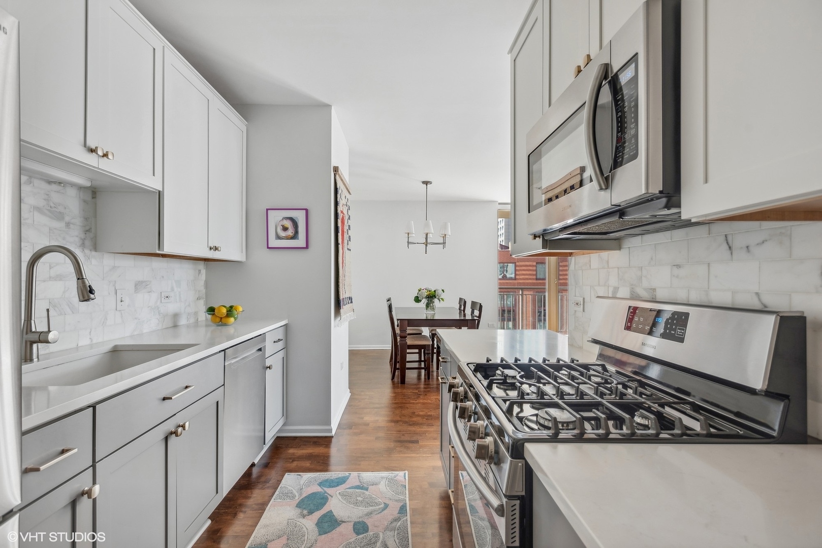 630 North State Street, Unit 1108 Chicago, IL 60654 - Photo 12 of 22 a kitchen with stainless steel appliances granite countertop a stove a sink dishwasher and cabinets with wooden floor