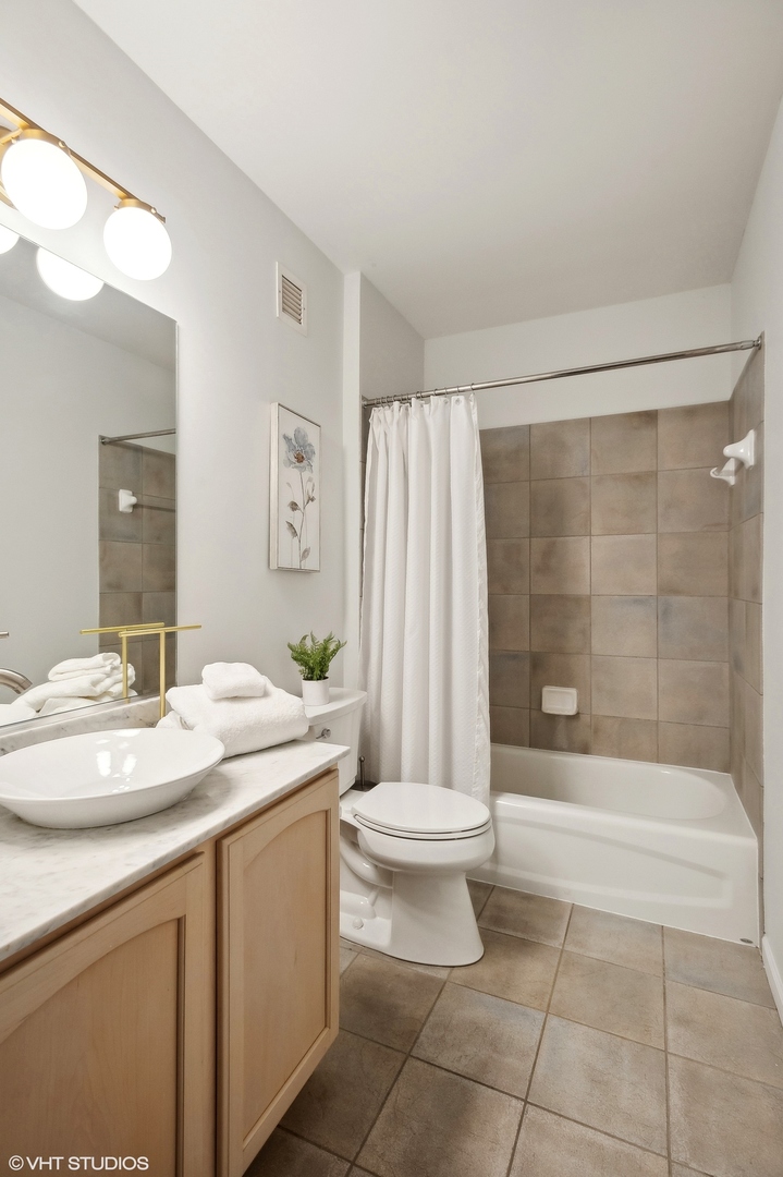 630 North State Street, Unit 1108 Chicago, IL 60654 - Photo 19 of 22 a bathroom with a sink a toilet and shower