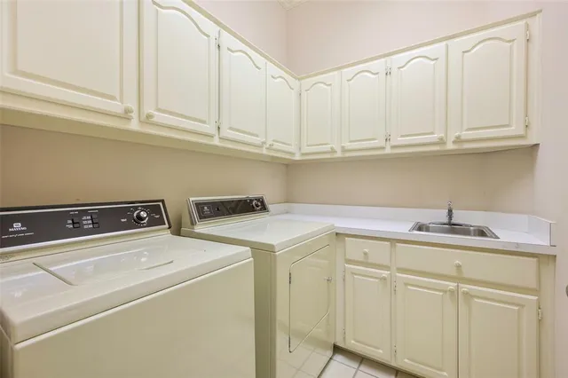 a kitchen with white cabinets and sink