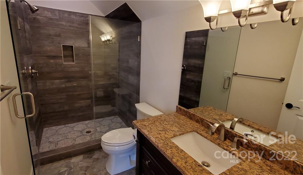 5201 Valley Stream Road Charlotte, NC 28209 - Photo 17 of 17 a bathroom with a granite countertop sink toilet and shower