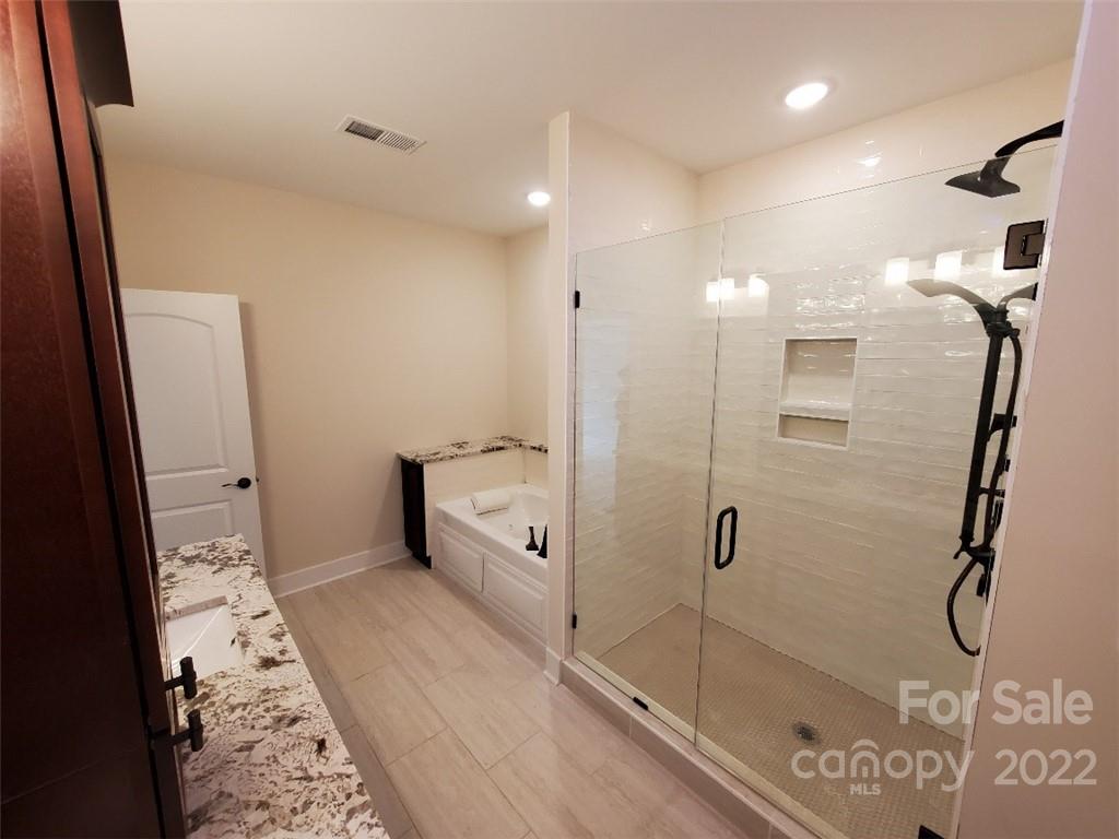 5201 Valley Stream Road Charlotte, NC 28209 - Photo 6 of 17 a bathroom with a glass shower door