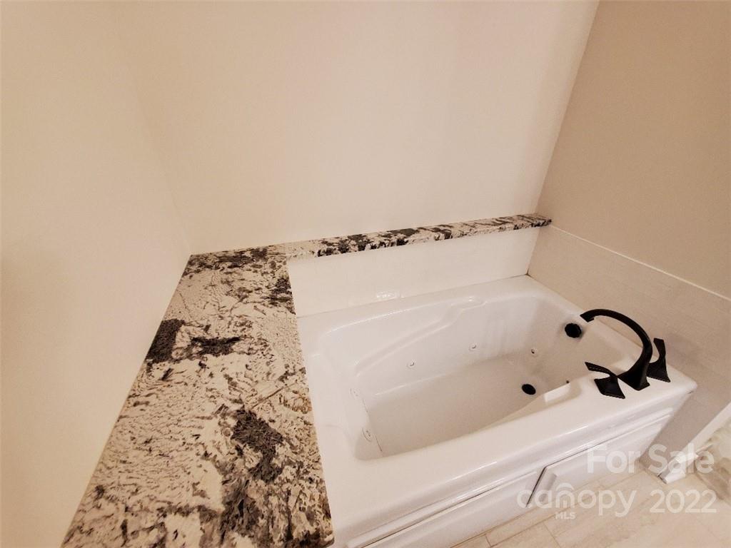 5201 Valley Stream Road Charlotte, NC 28209 - Photo 7 of 17 a bathroom with a bathtub and shower