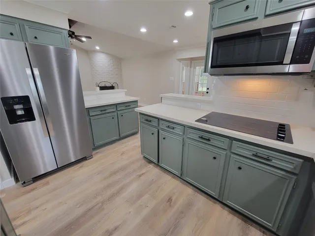 a kitchen with stainless steel appliances a stove microwave and sink
