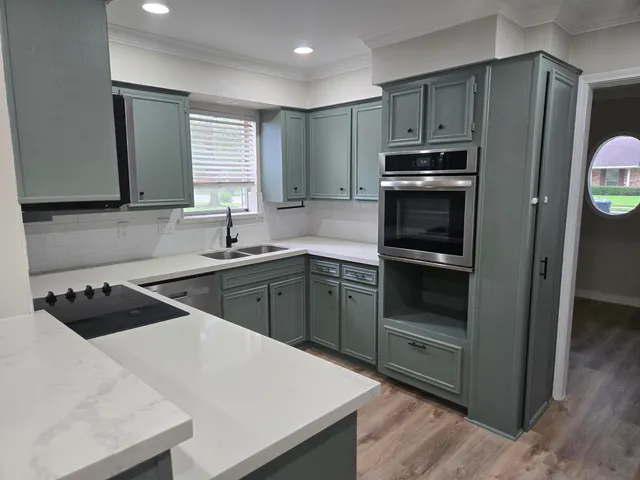 a kitchen with kitchen island a sink stainless steel appliances and cabinets