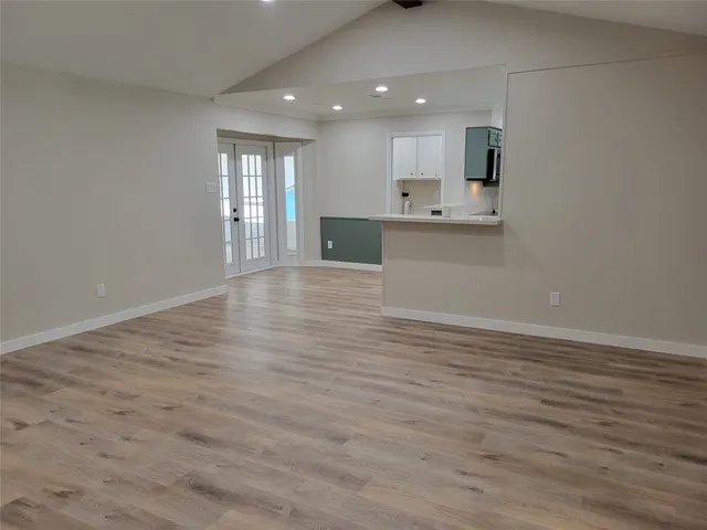 a view of kitchen with kitchen island a sink wooden floor and a refrigerator
