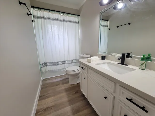 a bathroom with a double vanity sink toilet and shower