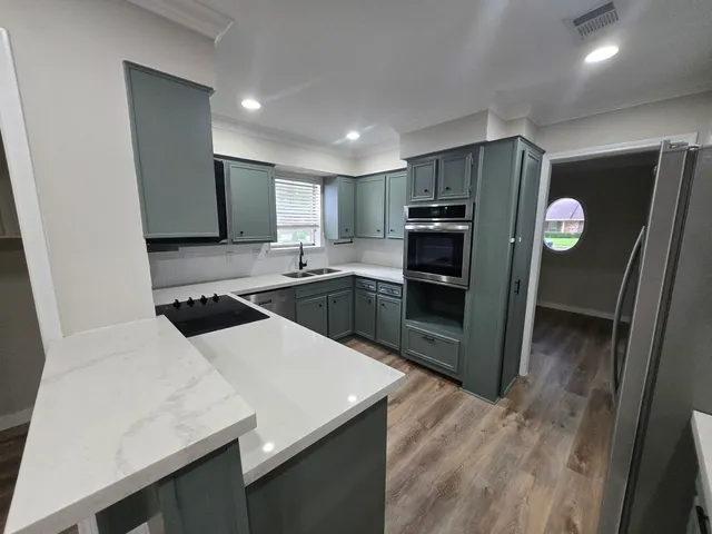 a kitchen with stainless steel appliances a refrigerator and a stove top oven