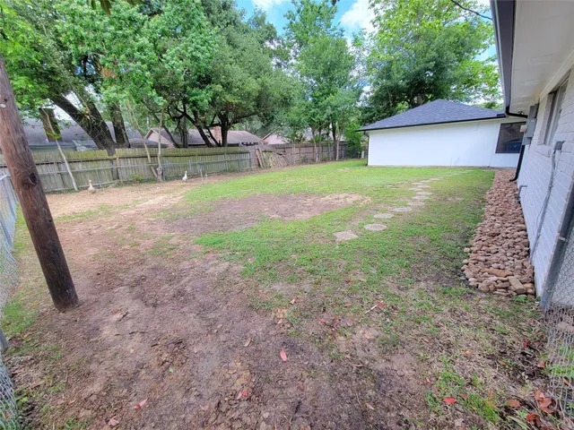 a view of a house with backyard and tree