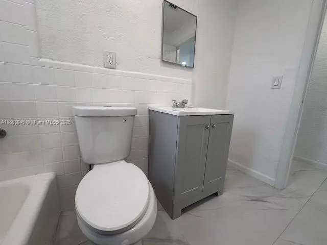 a white toilet sitting next to a bathroom sink