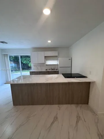 a kitchen with kitchen island sink and stove