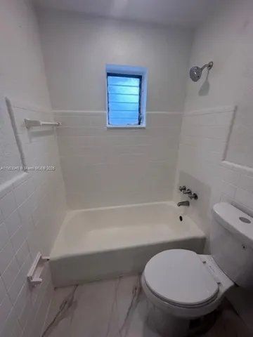 a bathroom with a toilet and a bathtub