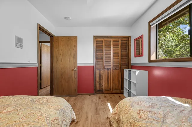 a large bed sitting in a bedroom next to a window