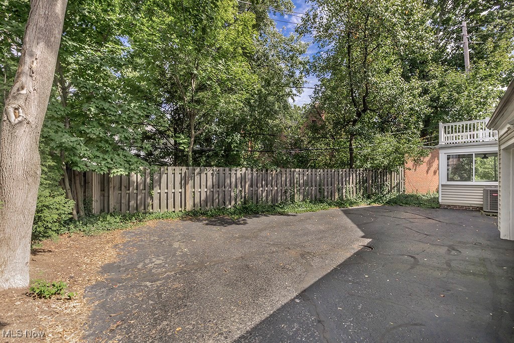 14711 South Woodland Road Cleveland, OH 44120 - Photo 29 of 31 An Efficient, Small, Low-Maintenance, Tree Shaded Rear Yard Includes a Wooden Privacy Fence Across the Back of the Property Line. The Three-Season Sunroom is seen in the Distance.