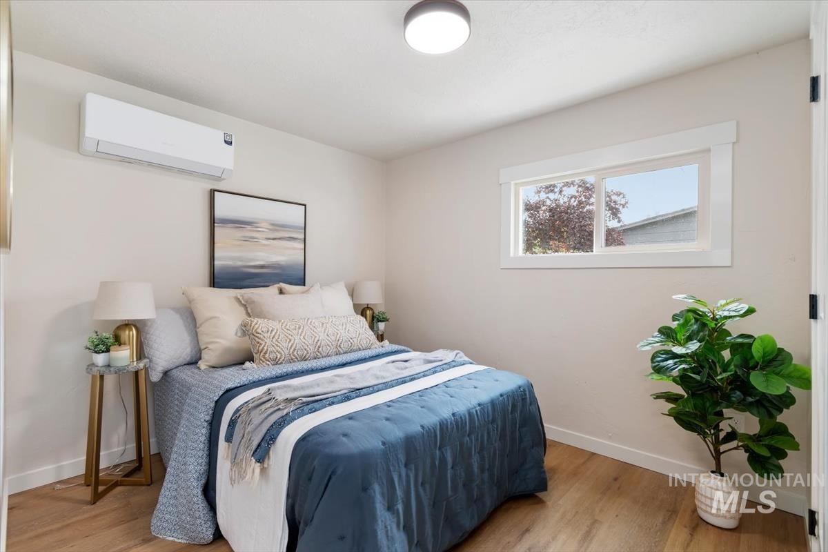 3005 West Hester Street Boise, ID 83702 - Photo 19 of 32 Bedroom featuring a window with white trim, wood-finish flooring, and a wall-mounted mini-split HVAC unit