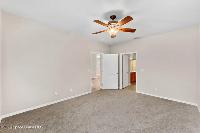 an empty room with a window and a ceiling fan