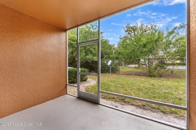 a view of an empty room with large windows