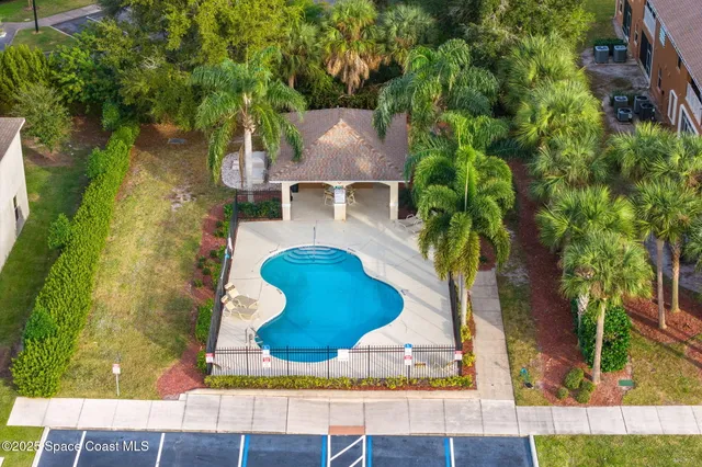 an aerial view of residential houses with outdoor space and trees