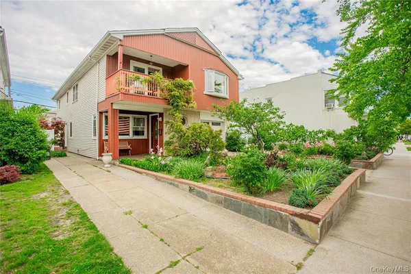 a front view of a house with a yard and potted plants