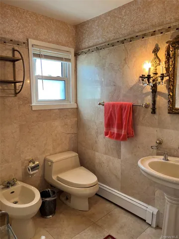 a bathroom with a toilet sink shower and mirror